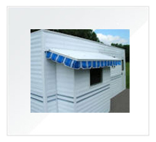 White RV With A Blue And White Awning.
