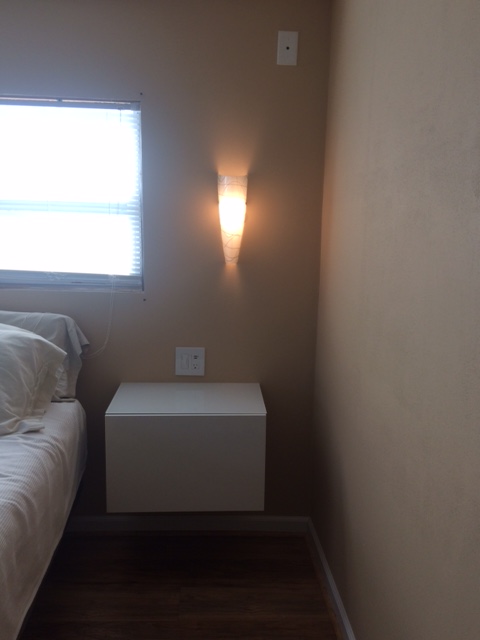 Floating White Nightstand Next To The Bed.