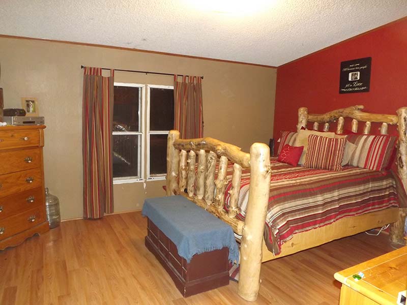 Bedroom With New Wood Floors, And Tan And Red Painted Walls.