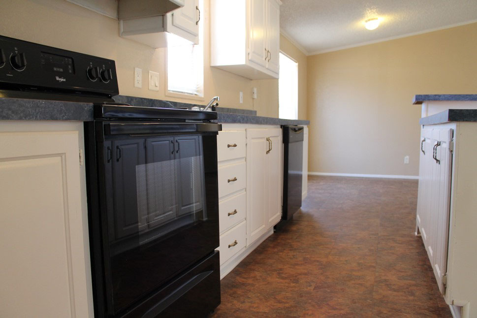 Close Up View Of Black Stove And White Cabinets With Blue Counter Tops.