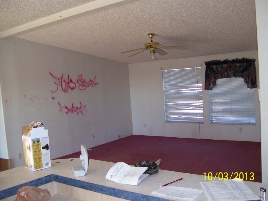 Living Room With White Walls With Red Graffit Spray Painted On, And Red Carpeting.