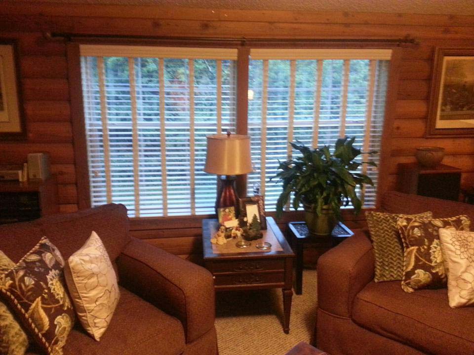 Living Room With Wood Walls And Custom Wood Blinds.