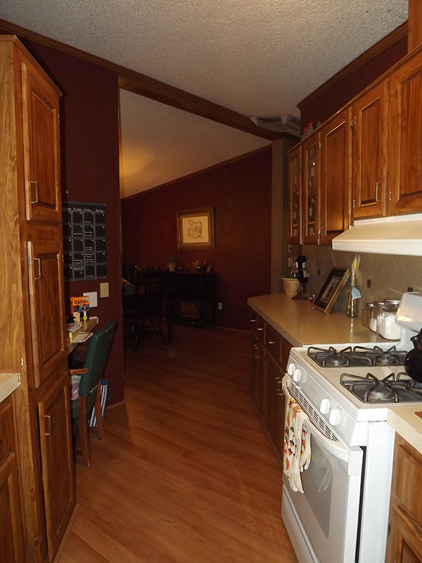Kitchen With New Wood Cabinets, Wood Floor, Beige Tile Backsplash And Red Painted Walls.