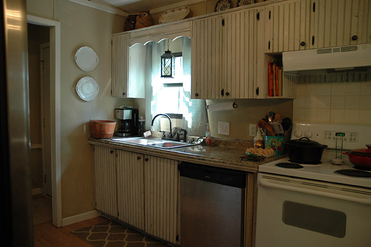Kitchen With Updated Appliances, White Painted Wood Cabinets And Painted Walls.