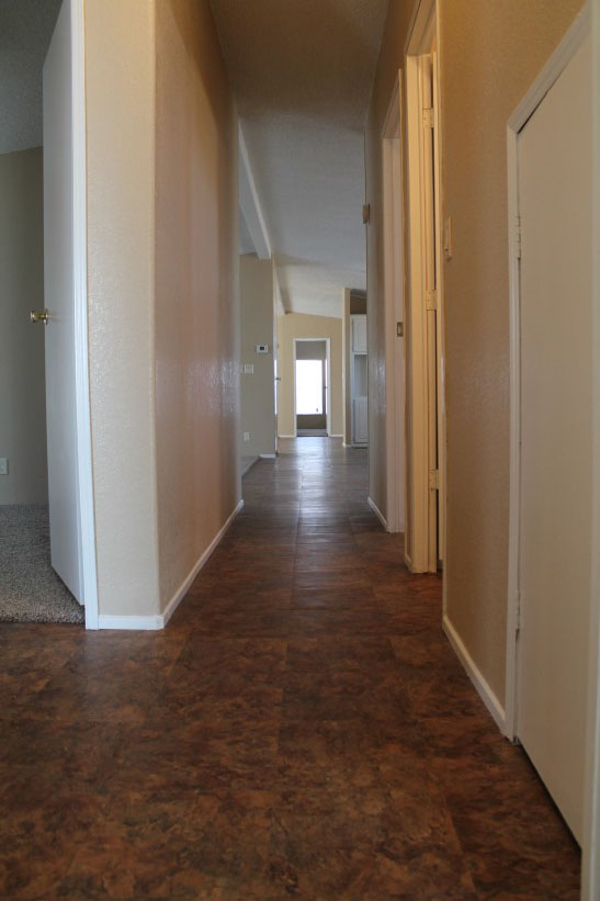 Hallway With New Brown Tile And Repaired Cream Colored Walls.