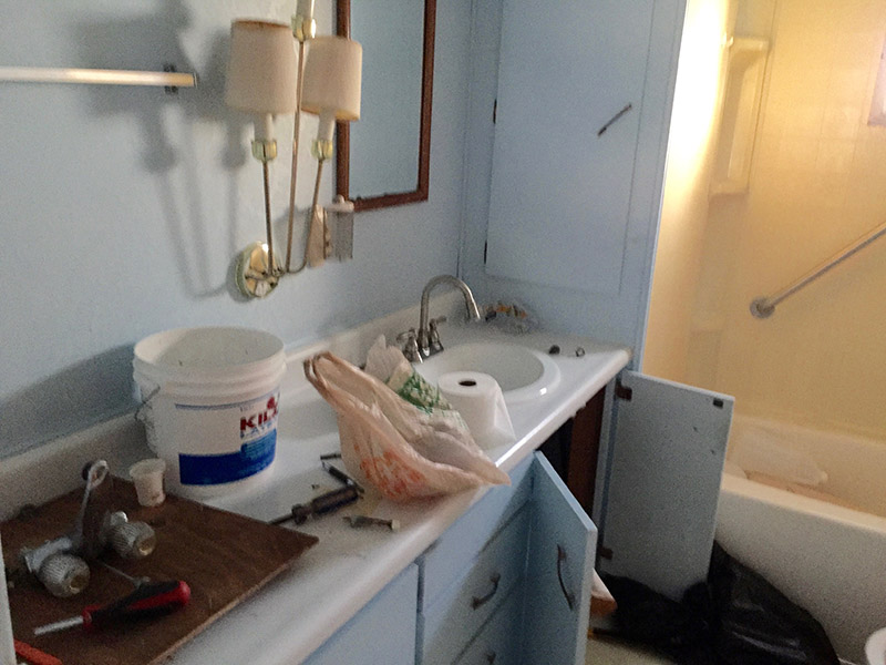 Light Blue Colored Bathroom With Home Improvement Items On The Sink.