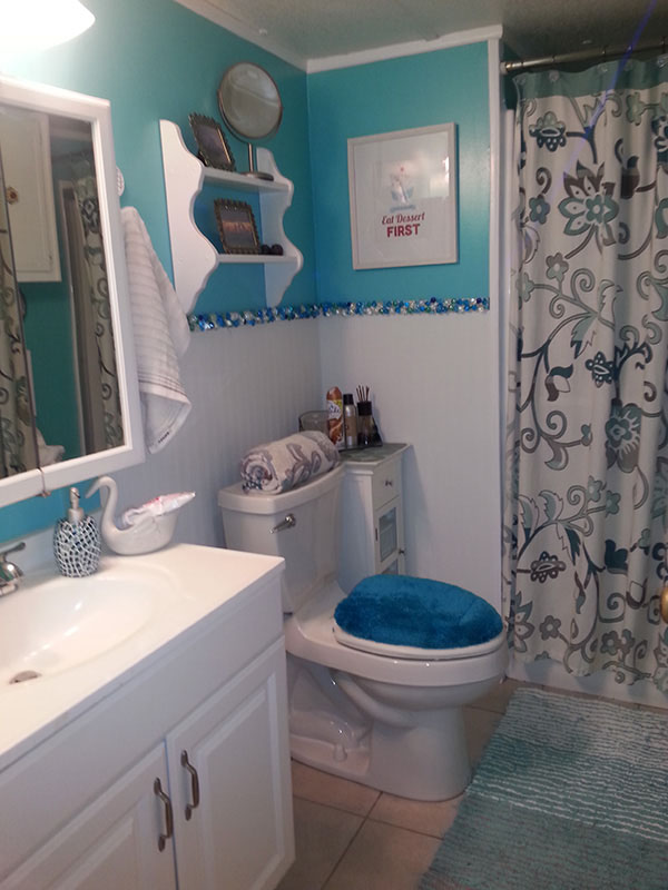 Bathroom With Bright Blue Walls At The Top, Sea Glass Separating The Blue From White Wainscotting.