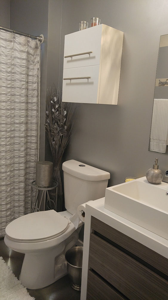 Bathroom With Grey Walls, And White Fixtures And A Silver Metallic Floor.