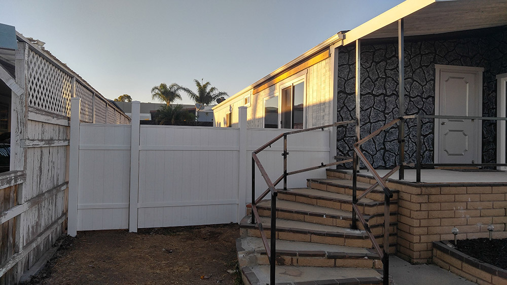 The Mobile Home With Updated Reil Rock Siding, A New Front Door, And A New Fence.
