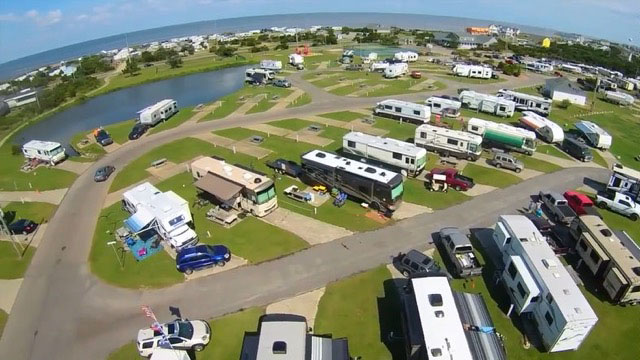 Overhead View Of RVs Next To A Pond.