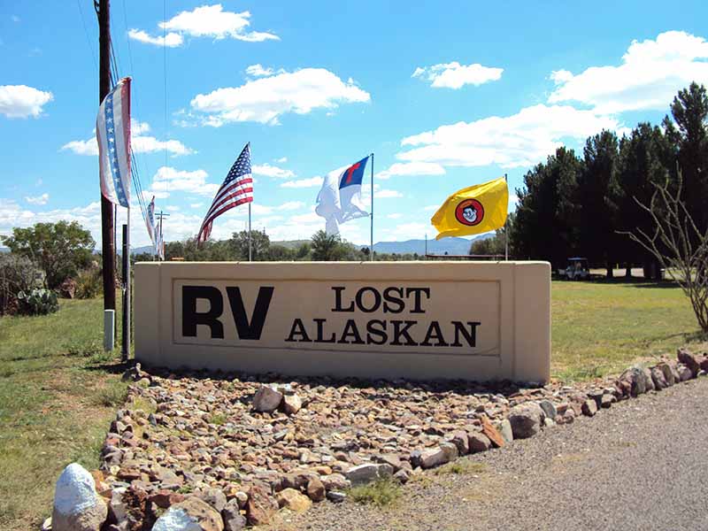 Lost Alaskan Sign With Flags Flying.