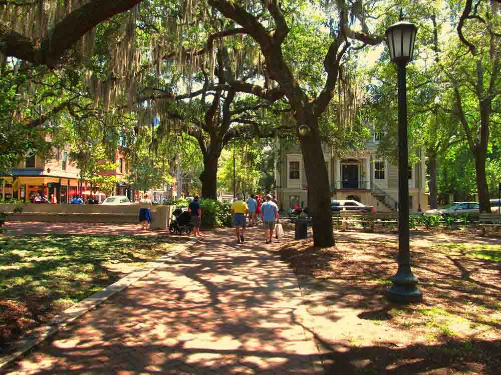 Downtown Savannah, Georgia On A Sunny Day With People Walking Under The Shaded Courtyard.