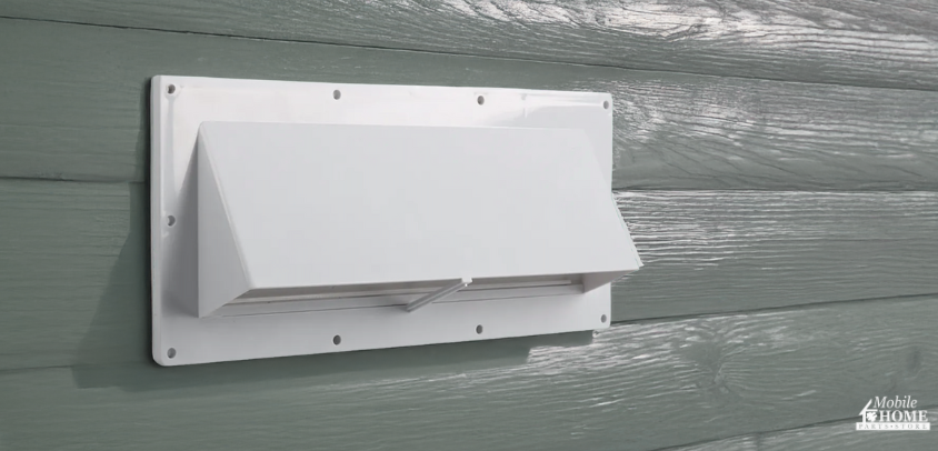 Ventline range hood vent on the side of a mobile home with green lap siding