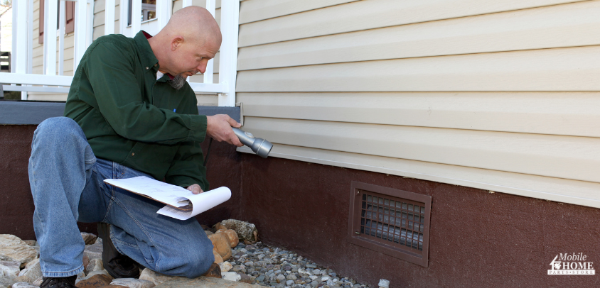 man checking mobile home crawl space ventilation